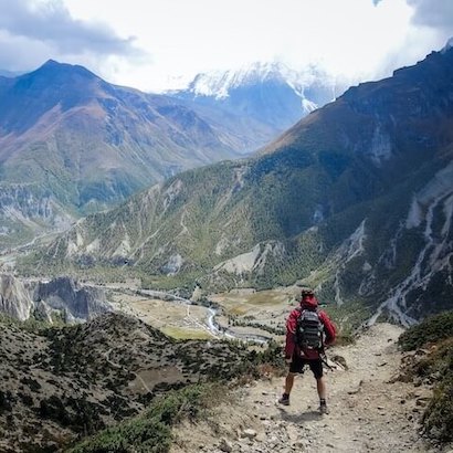 Hiker trekking through the stunning mountains of Albania, with scenic views of Valbona Valley and Theth.