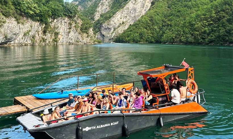 Group camping along Berisha River, Albania – Boat trip, crystal-clear waters, mountains, and nature.