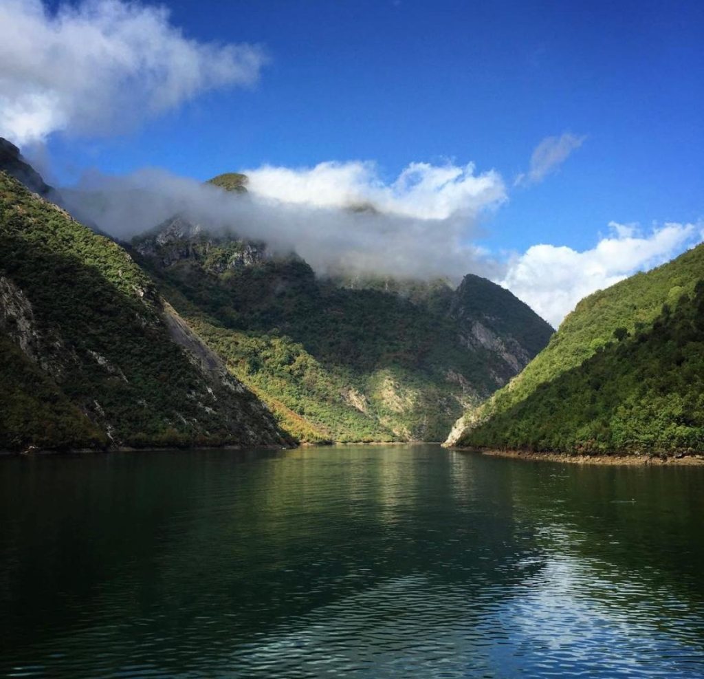 Scenic view of Komani Lake in Albania, showcasing the stunning natural surroundings and clear blue waters.