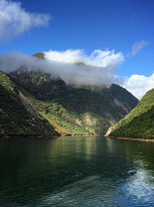 Scenic view of Komani Lake in Albania, showcasing the stunning natural surroundings and clear blue waters.