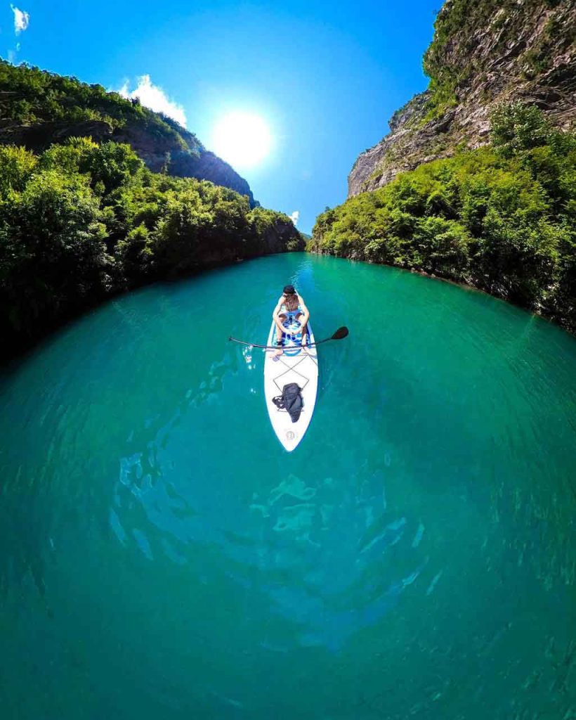 Rafting adventure on a river in Albania, with clear water and surrounded by mountains.