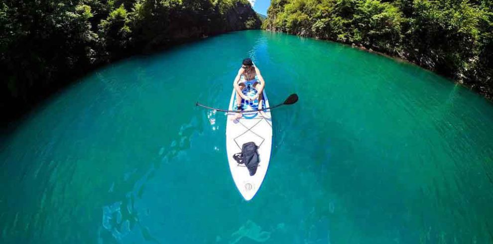 Rafting adventure on a river in Albania, with clear water and surrounded by mountains.