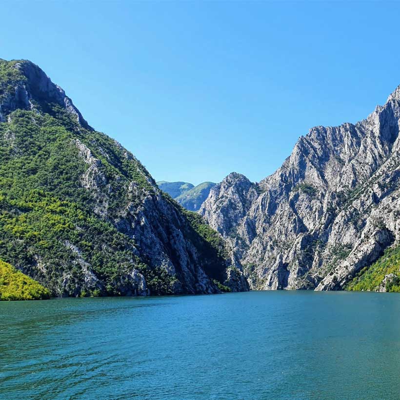 Breathtaking mountain views of Fierze, Albania, with clear blue waters of the reservoir.